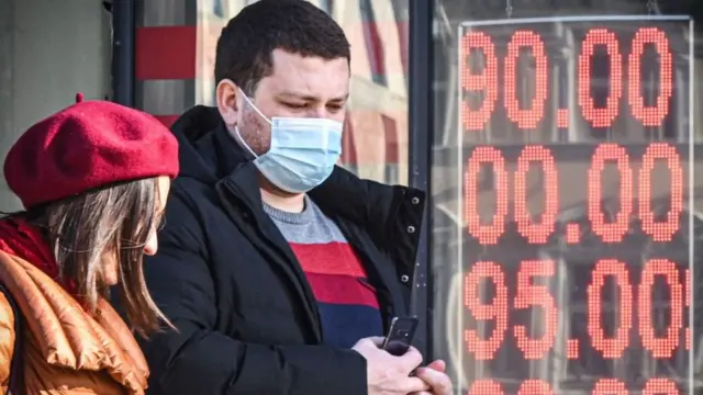 People walk past a currency exchange office in central Moscow on February 28, 2022