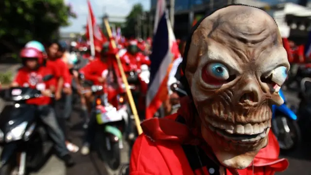 ผู้สนับสนุนทักษิณ ชินวัตรใส่หน้ากากขณะเดินขบวนประท้วงเมื่อวันที่ 12 เมษายน 2010