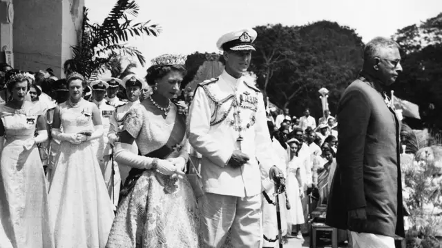 බ්‍රිතාන්‍යයේ එලිසබත් රැජින සහ පිලිප් කුමරුගේ පළමු ශ්‍රී ලංකා සංචාරය අතරතුර ඉදිරියෙන් ගමන් කරන එවකට අග්‍රාමාත්‍ය ජෝන් කොතලාවල