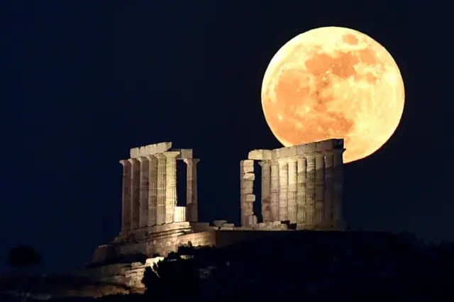 زهرة القمر الدموي العملاق تظهر فوق معبد بوسيدون في كيب سونيون بأثينا في اليونان.