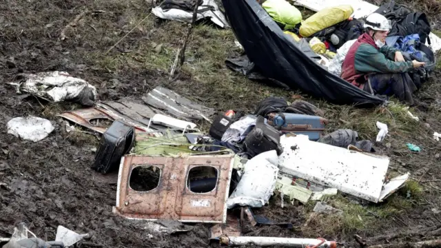 Socorrista entre pedazos del avión accidentado