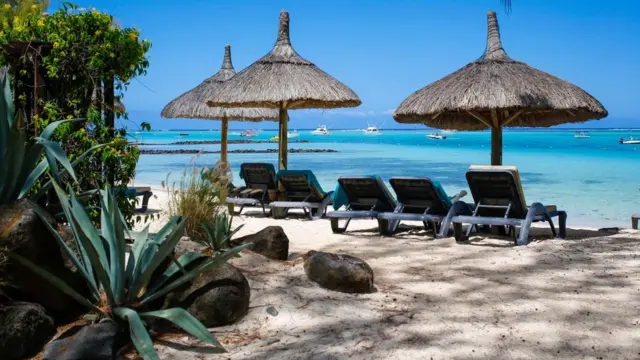 La plage de sable blanc avec des bancs solaires au Beachcomber Hotel le 05 décembre 2016 dans la péninsule du Morne, à l'île Maurice