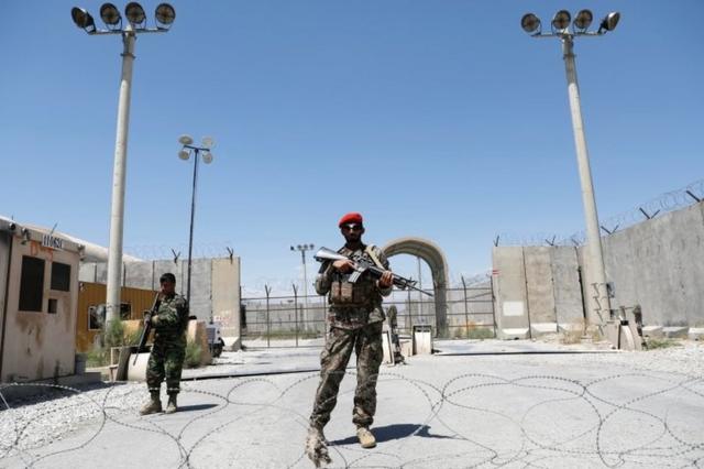 Afghan soldiers stand guard at the gate of Bagram Airfield, 2 July
