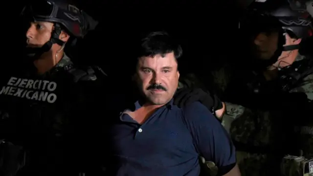 photo taken on January 8, 2016 Drug kingpin Joaquin "El Chapo" Guzman is escorted into a helicopter at Mexico City"s airport following his recapture during an intense military operation in Los Mochis, in Sinaloa State. -