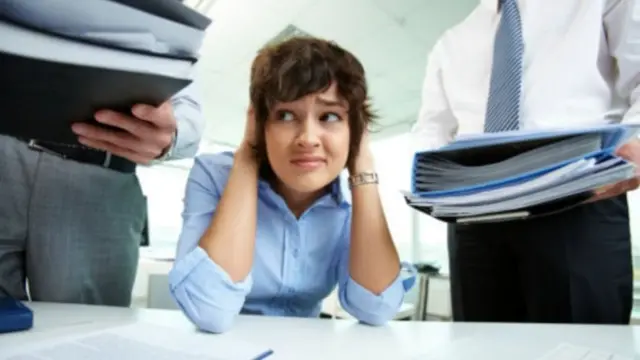 فتاة محاطة برجلين يحملان أكواما من الملفات المطلوب انجازها