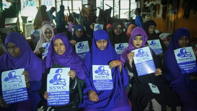 Somali female activists hold messages 'Save Somali Women and children' gather to mark International Womens Day in Mogadishu on March 8, 2018.