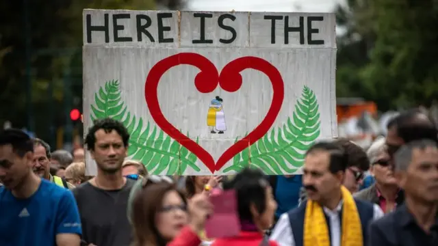 People hold up a banner as they take part in a march to remember victims of the Christchurch mosque attacks
