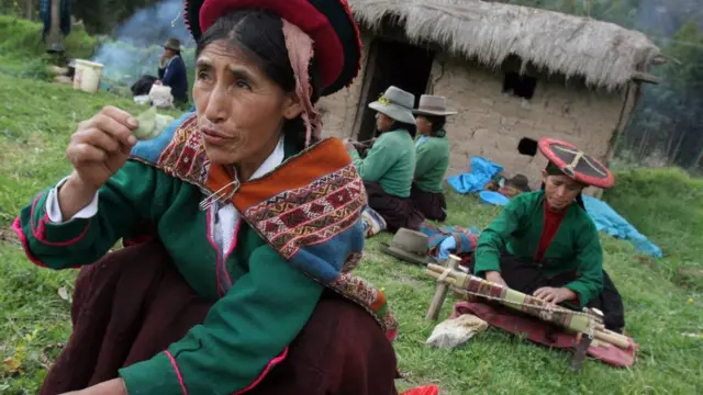 Mujer sosteniendo una hoja de coca