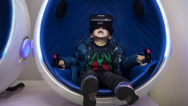 一个男孩在体验VR（虚拟现实）技术。