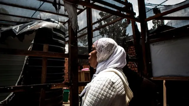 A woman looks at burned equipment in an Ebola treatment centre, which was attacked in Butembo