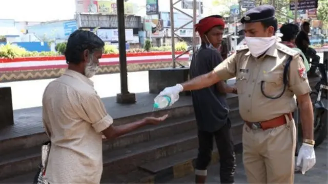 પોલીસ સાથે હાથ સાફ કરતી વ્યક્તિ