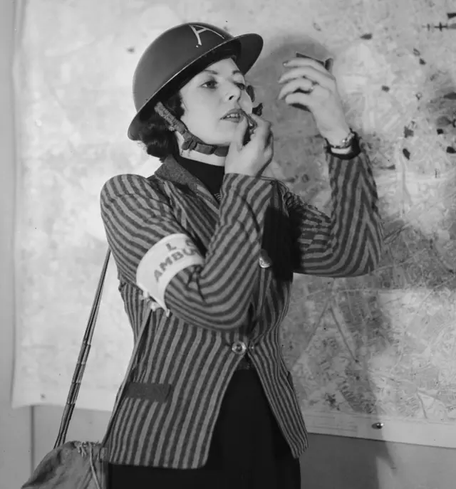 Una mujer se coloca lápiz labial en Londres en 1940.