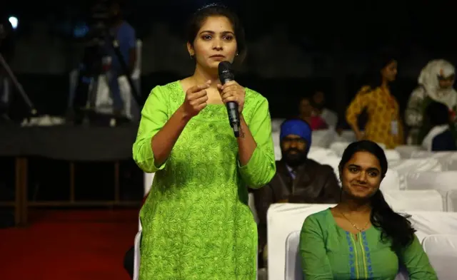 ప్రశ్న వేస్తున్న ఒక యువతి