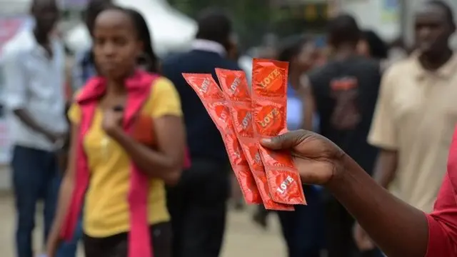 Un hombre reparte preservativos en la calle.