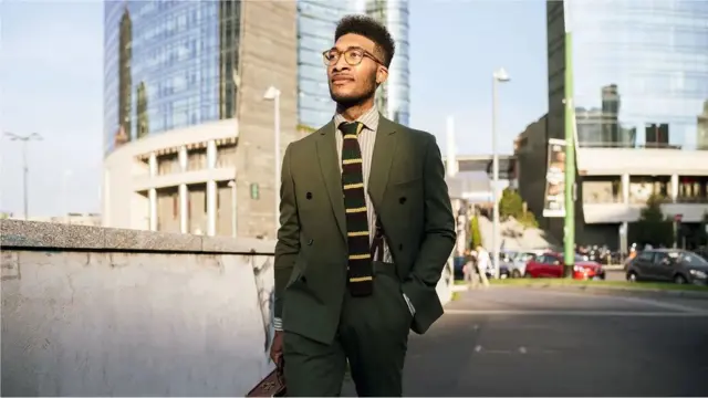 잘 차려입는 한 남성이 길을 걷고 있다