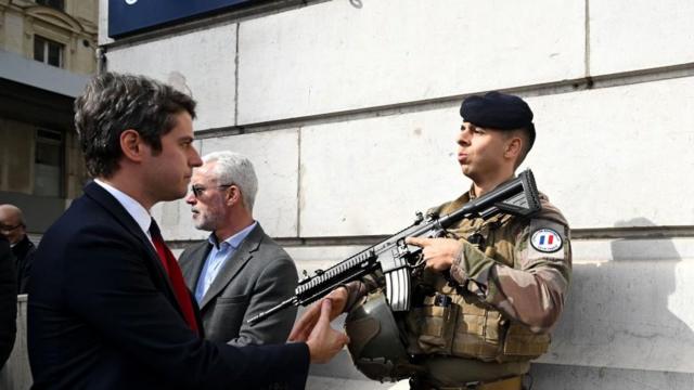 2024年3月25日，法国总理加布里埃尔·阿塔尔（左）在访问法国巴黎圣拉扎尔火车站时向一名执勤的法国士兵致意。