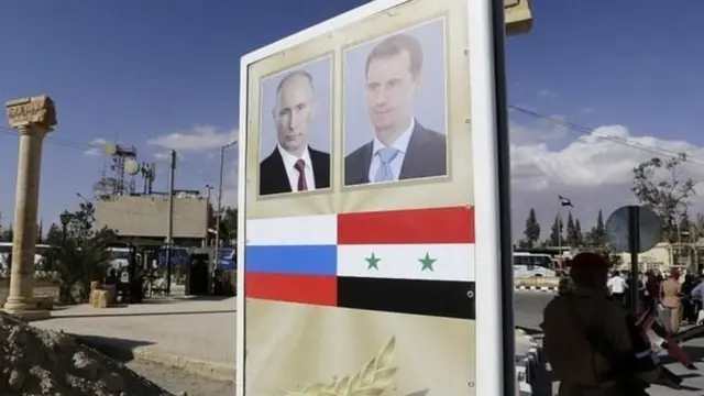 सीरिया में लगे एक पोस्टर पर ब्लादिमीर पुतिन और बशर अल असद की फोटो.