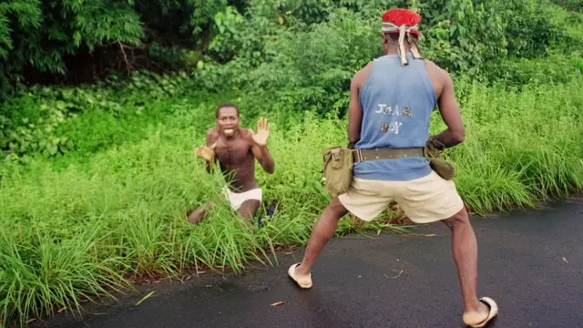 Hombre armado apunta a un hombre durante la guerra civil de Liberia.