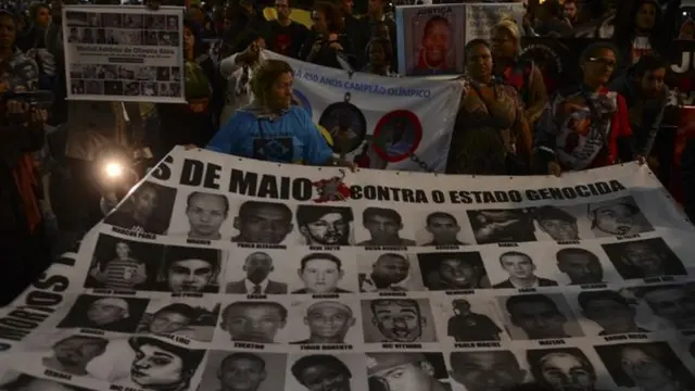 Protesto no centroSão Paulo com cartaz com rosto das vítimas