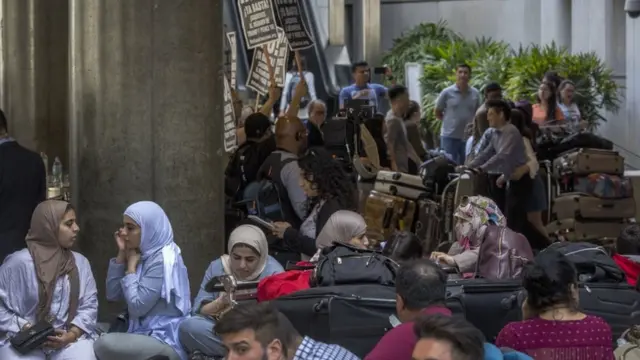 ناشطون ومسافرون في صالة الانتظار بالمطار خلال اليوم الأول من سريان مفعول قرار الحظر