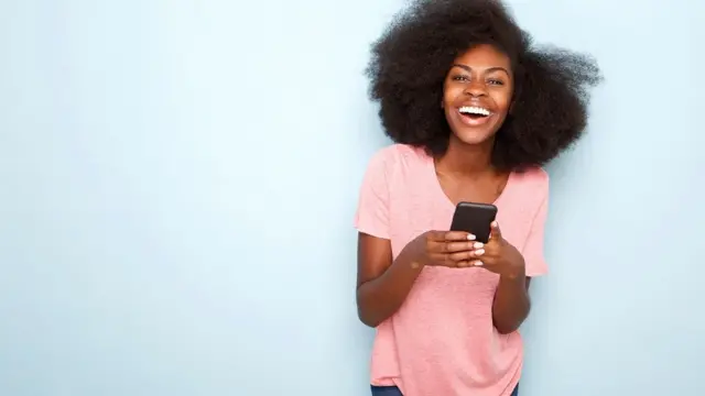 Jeune femme heureuse tenant un téléphone intelligent