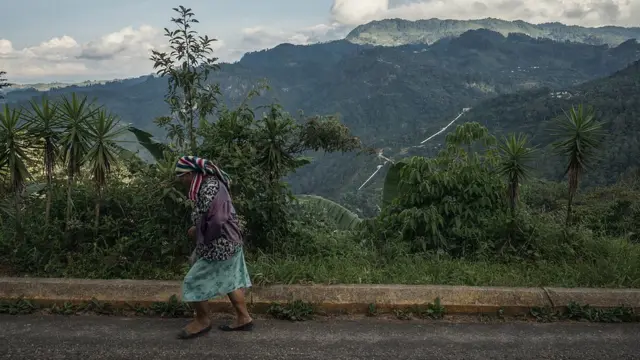 Una mujer camina sobre una vía cercana a la presa Aurora.