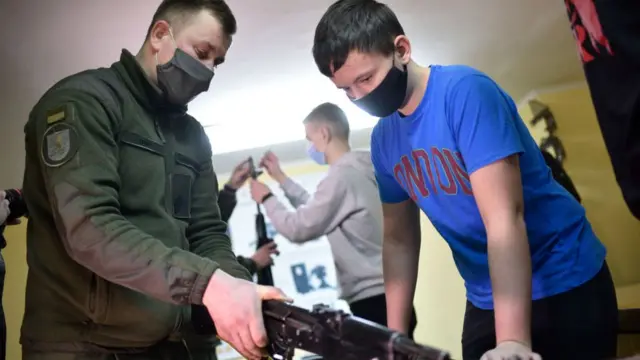 Un chico recibe formación en el uso de armas