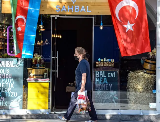 Женщина идет мимо магазина с флагами Азербайджана и Турции в Баку