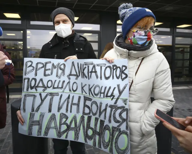 Люди с плакатом "Путин боится Навального" в аэропорту Бранденбург