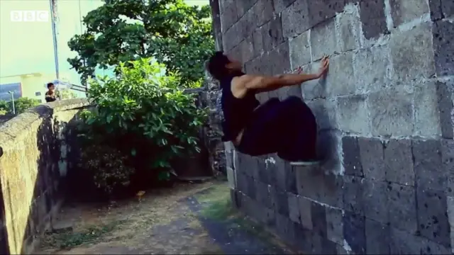 คนกระโดดยันกำแพงตีลังกากลับหลัง