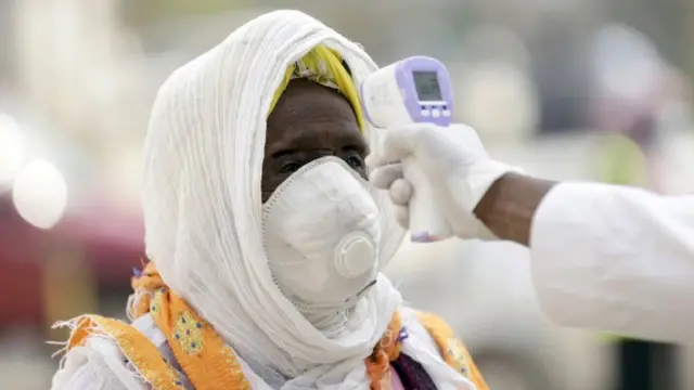 Des agents de santé prennent la température des fidèles avant qu'ils n'entrent dans l'église à Addis-Abeba, juin 2020