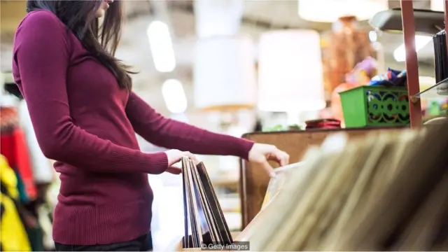 Seorang perempuan melihat-lihat album vinyl.