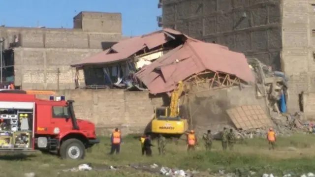 Excavator arrives at site of collapsed building