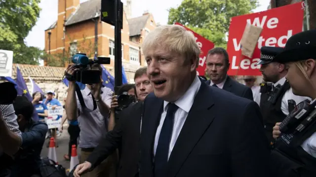Johnson caminha em rua de Londres acompanhado por fotógrafos e manifestantes pró-Brexit