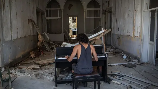 Музикант Раймонд Ессаян грає на фортепіано у зруйнованій будівлі після вибуху в порту Бейрута, Ліван, 14 серпня 2020 року