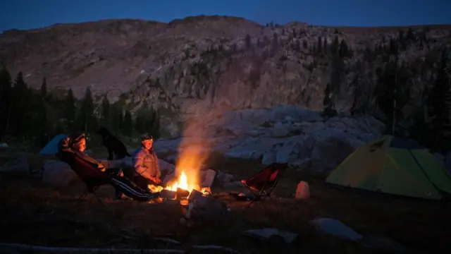 بعد يوم شاق بالجبال جلس باحثان للاستدفاء حول نار المخيم