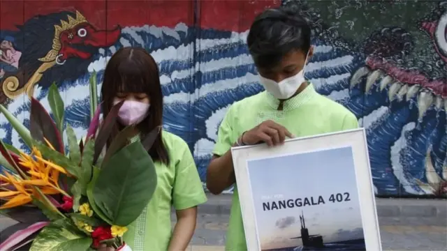 Warga membawa bunga dan berdoa untuk seluruh awak kapal selam KRI Nanggala-402 yang hilang di perairan utara Pulau Bali saat aksi simpatik di Solo, Jawa Tengah, Minggu (25/04).
