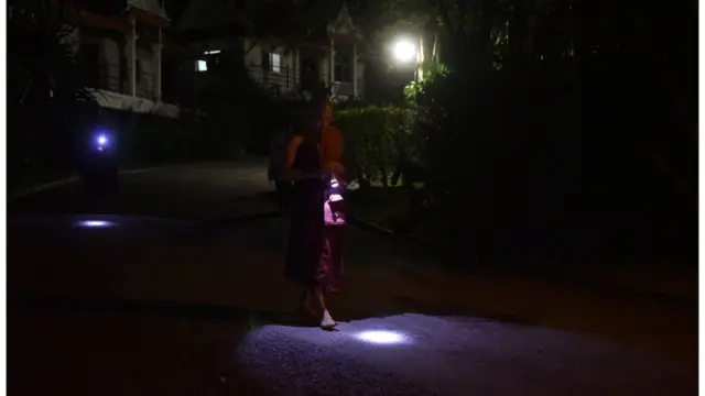 พระเดินส่องไฟก่อนไปที่ศาลาปฏิบัติธรรม