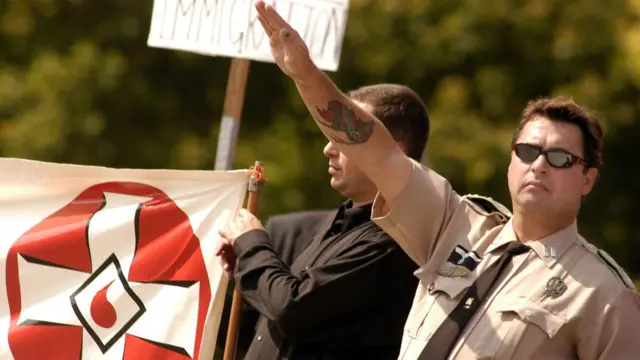 নাৎসী স্যালুট দিচ্ছে একটি নাৎসাবাদী গোষ্ঠীর একজন সদস্য।