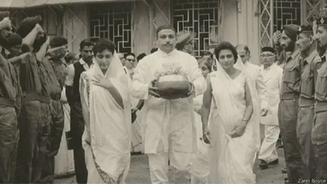 கர்னல் தாராபோரின் அஸ்தி கலசத்தை எடுத்துச் செல்லும் மனைவியும் மகளும்