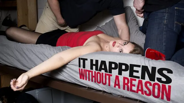 Mujer en una cama con dos hombres empezando a desnudarse