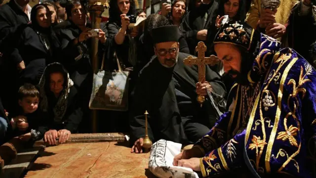 游客和朝圣者亲吻涂膏礼之石，他们相信耶稣在葬礼前正是在这块石头上完成清洗等仪式的