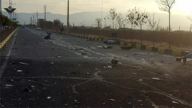 Estrada com restosslot machineum veículo que teria sido detonado perto do carroslot machineFakhrizadeh