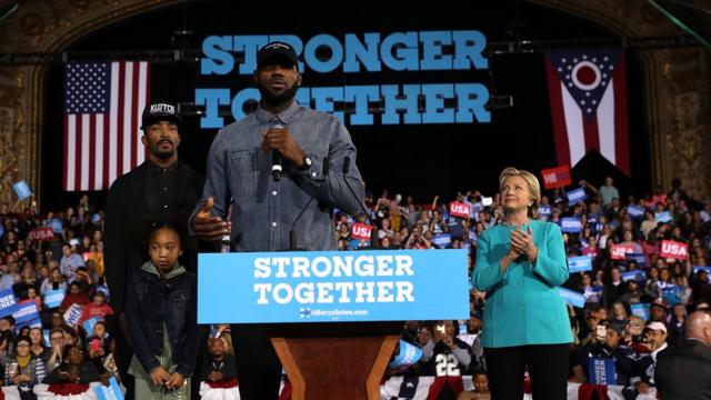 LeBron James (C) speaks as Democratic presidential nominee former Secretary of State Hillary Clinton (R) and J.R. Smith (L) look on during a campaign rally at the Cleveland Public Auditorium on November 6, 2016 in Cleveland, Ohio.