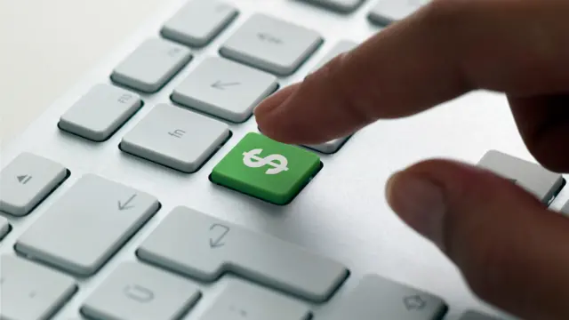 Mano sobre un teclado con el símbolo de dólar