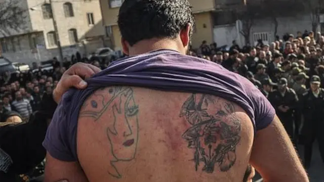 نیروی انتظامی به نشانه تحقیر بدن خالکوبی شده متهمان را به مردم نشان میدهد