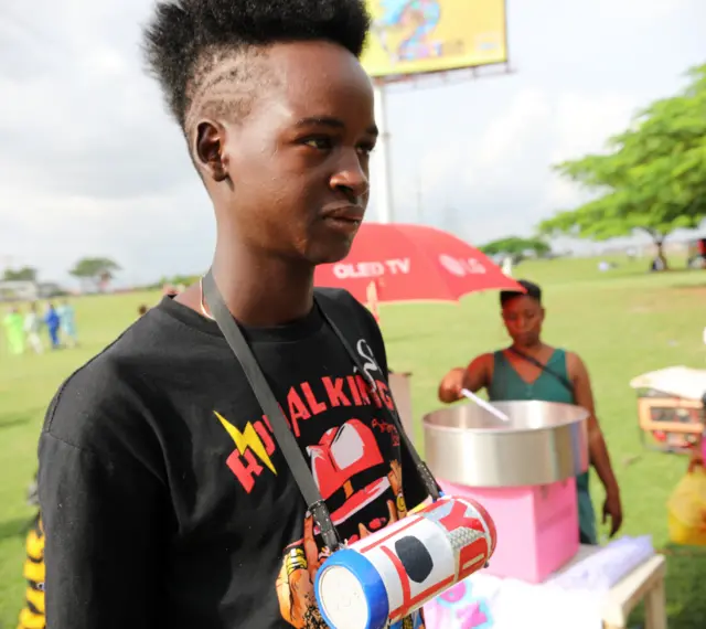 A Fulani boy with a punk hairdo and radio across his chest