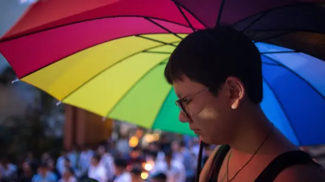 Mujer con paraguas de arcoiris