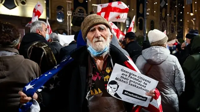 Kişi əlində Saakaşvilinin şəklini tutur