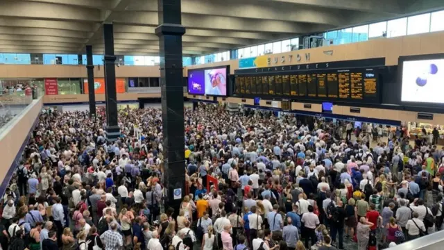 مسافرون تقطعت بهم السبل في محطة يوستن للقطارات في لندن يوم 25 يوليو/تموز بسبب ارتفاع درجات الحرارة